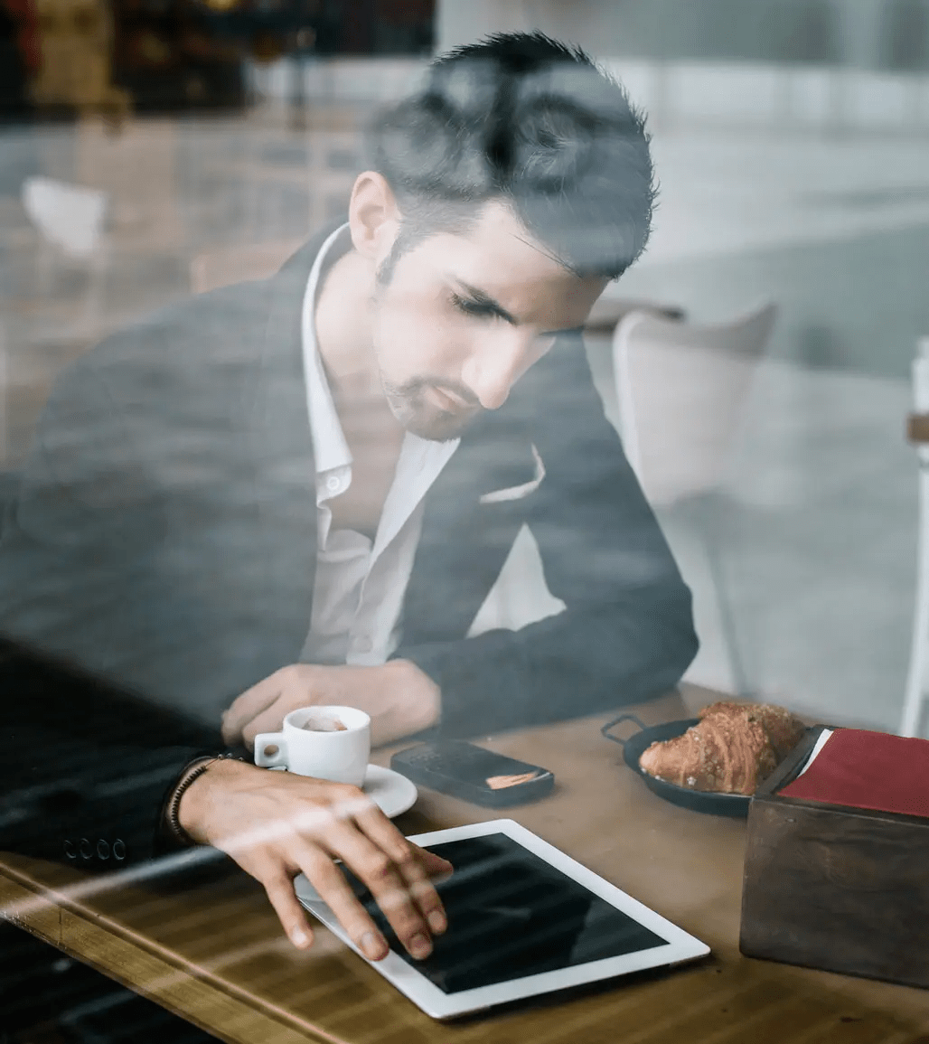 Business person working in a coffee shop with a tablet