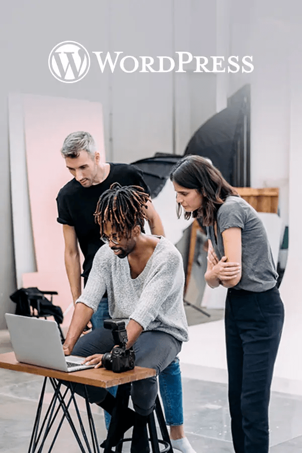 Three business owners looking at laptop in studio