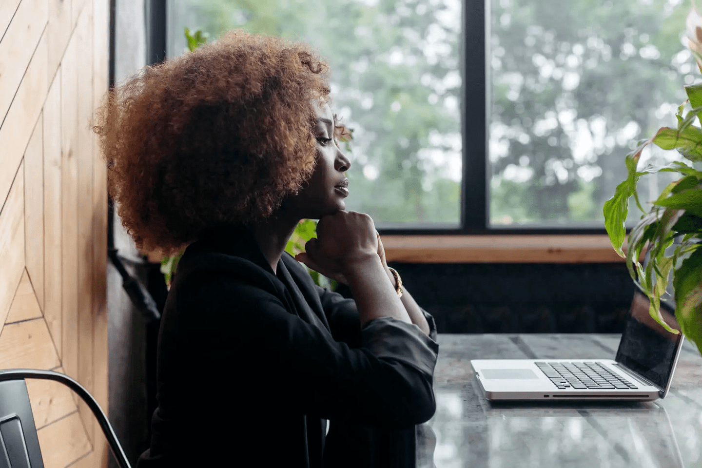 Woman sitting with a laptop composing an email.