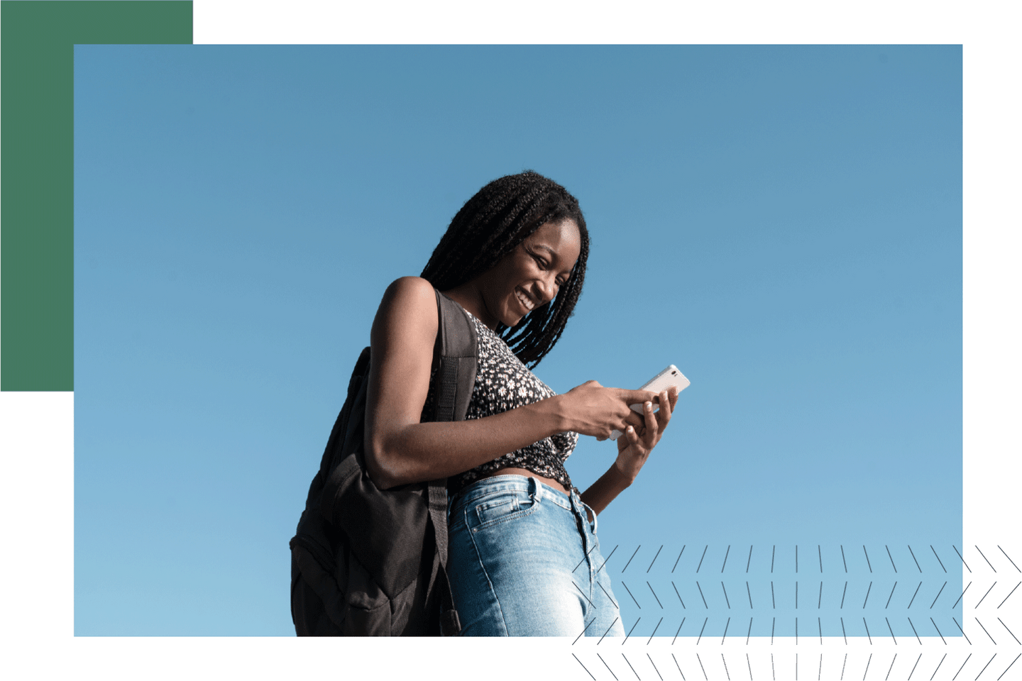 Woman standing outside smiling at her cell phone