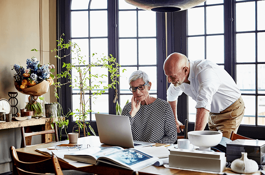 A couple people looking at laptop in their office