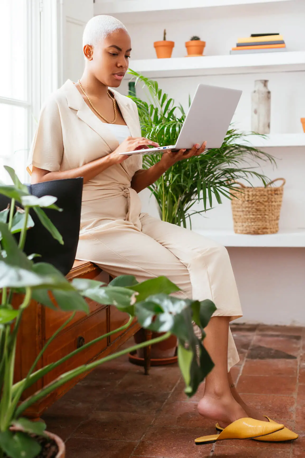 Woman sitting on a desk searching on laptop