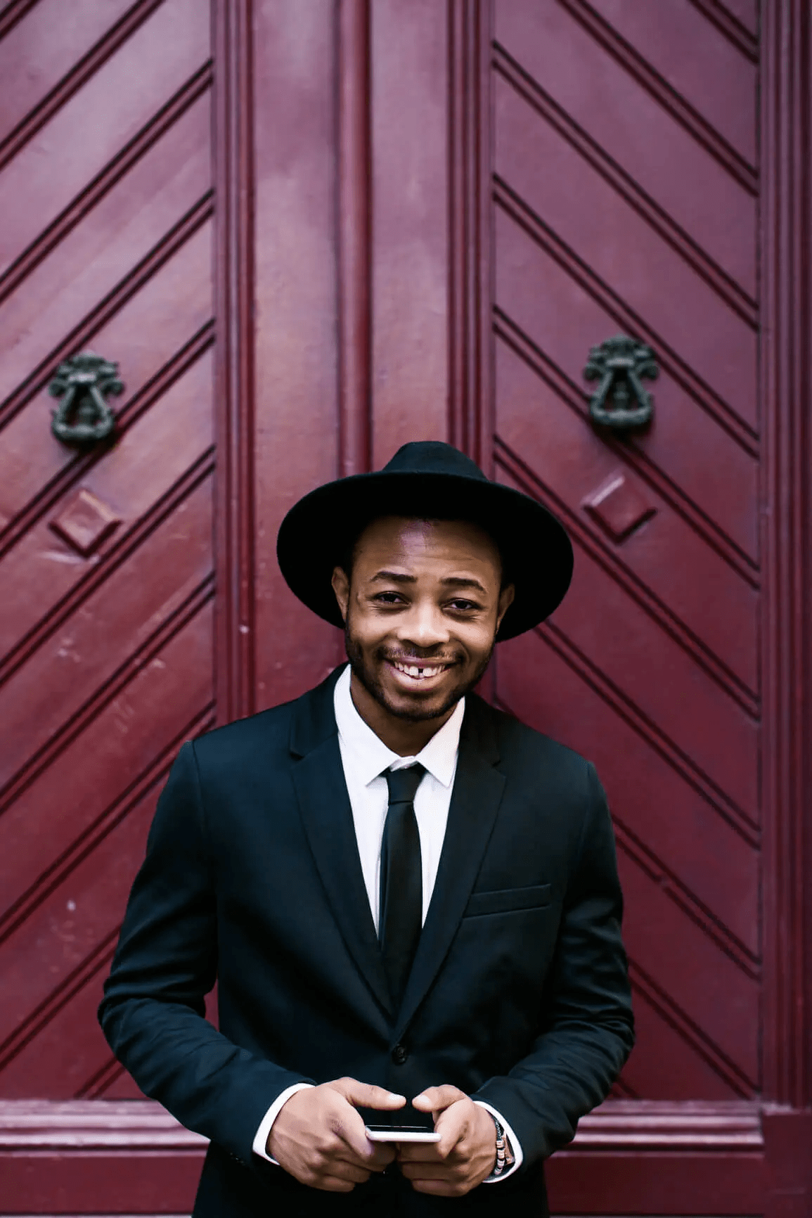 Man smiling while holding phone