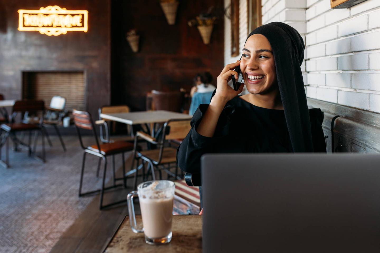 A women talking on the phone in a coffee shop